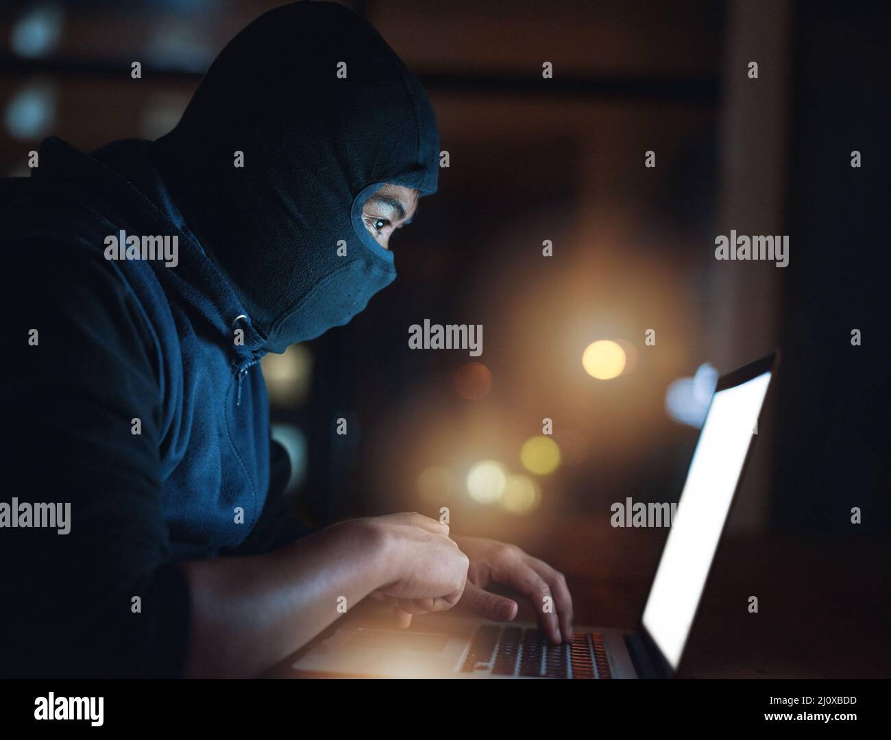 Wie sicher ist Ihr System wirklich? Aufnahme eines Hackers mit einem Laptop im Dunkeln. Stockfoto