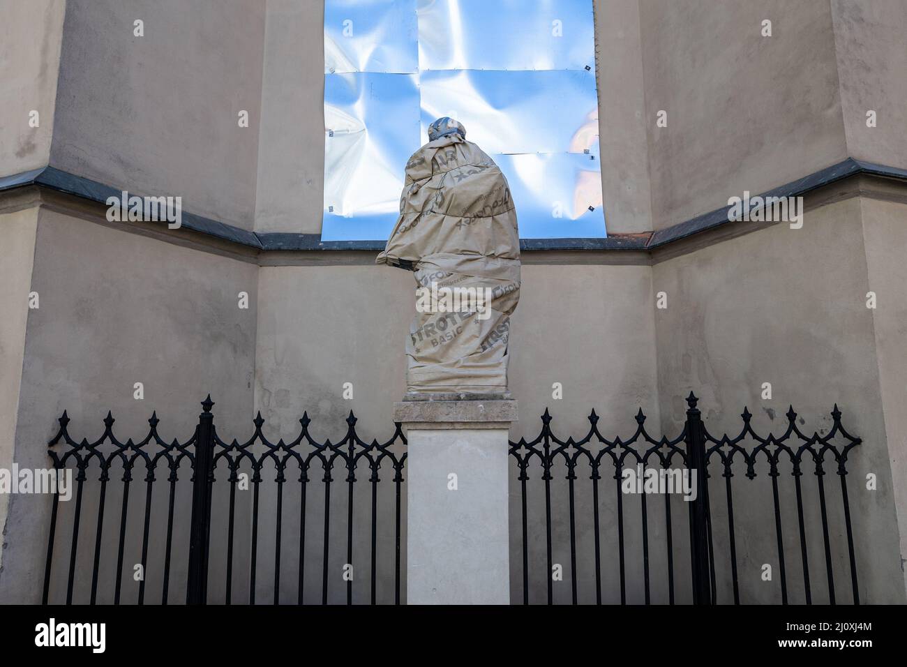 LVIV, UKRAINE - 20. März 2022:um sie vor Schäden zu schützen, werden Skulpturen der Heiligen der lateinischen Kathedrale eingewickelt und Glasmalerei mit glasmalerei Stockfoto