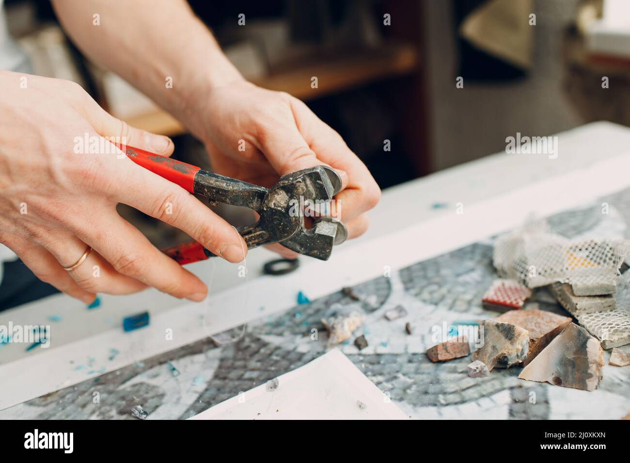 Handwerker Schneiden von Smaltglas mit Zangen Cutter für die Herstellung von Smaltglas Mosaik. Stockfoto
