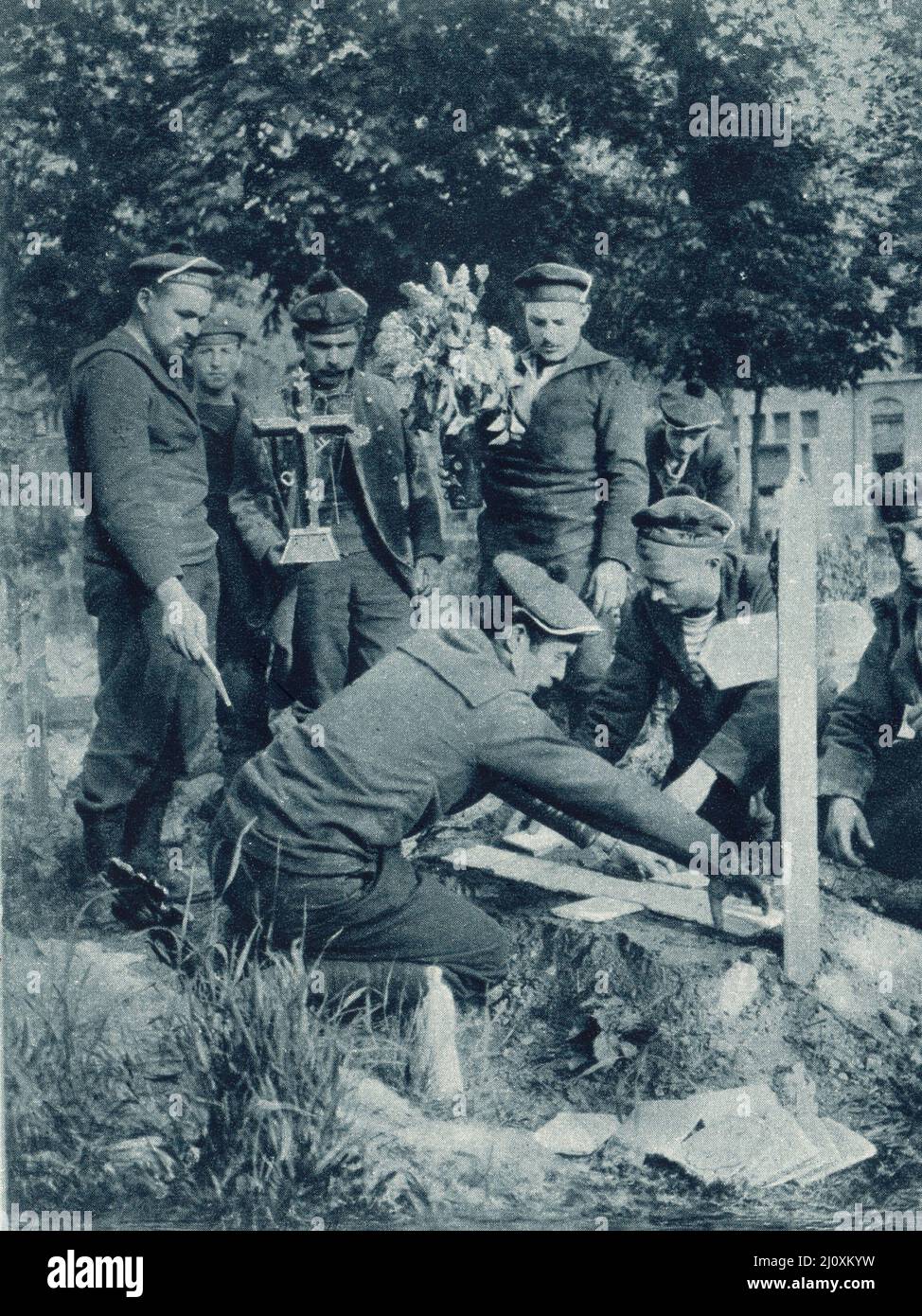 Männer der französischen Marinebrigade legen Fliesen und ein Kreuz auf ein Kameradengrab; Nieuport, Belgien, 1915. Schwarzweiß-Foto Stockfoto