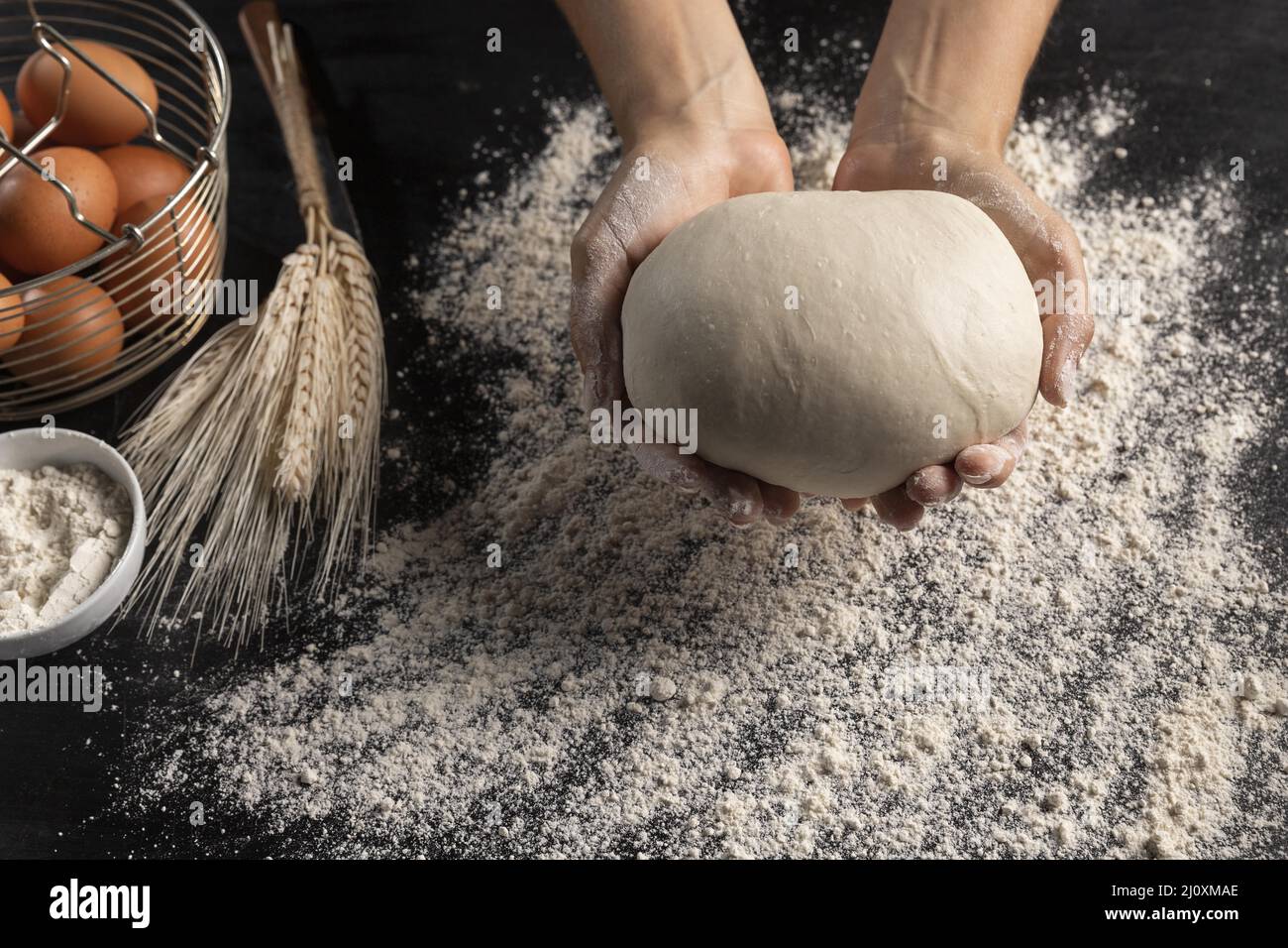 Der Koch mit Blick von oben hält den Brotteig. Hochwertiges, schönes Fotokonzept Stockfoto