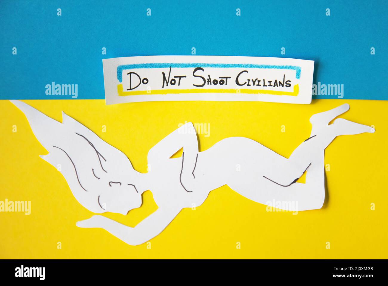 Körper einer auf dem Boden liegenden Frau, die die von den Russen in der Ukraine getötete Zivilbevölkerung darstellt. Stockfoto