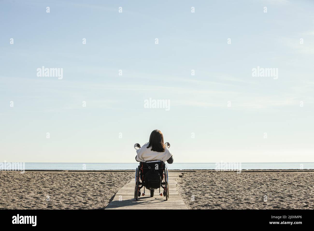 Rückansicht Frau Rollstuhl Strand. Hochwertiges, schönes Fotokonzept Stockfoto