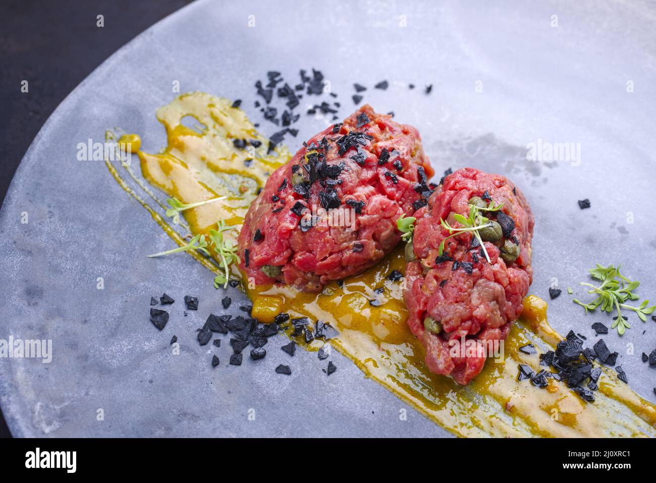 Roher Gourmet-Tartar im modernen Stil aus Rinderfilet mit Senfsauce und ...