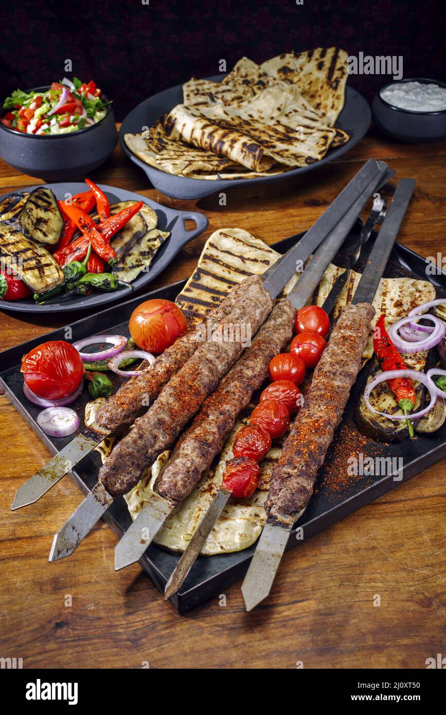 Traditioneller türkischer Adana Kebap auf Schaschlik-Spieß mit Grillgemüse Stockfoto