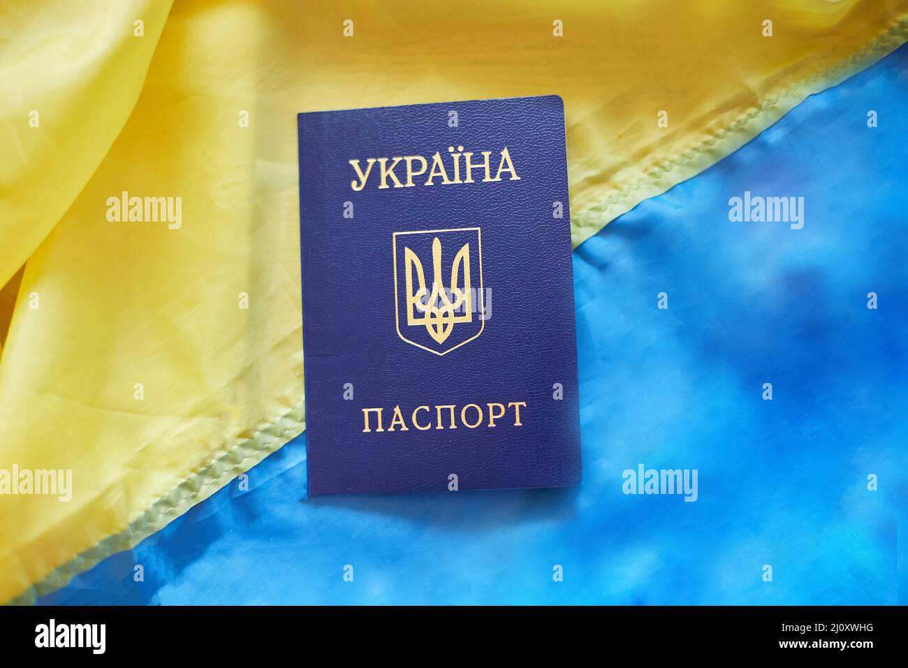 Drei ukrainische nationale Pässe auf der Flagge der Ukraine Stockfoto