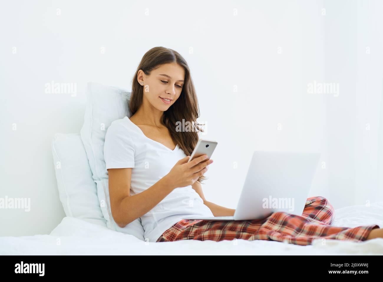 Junge Frau online einkaufen, Eingabe von Code aus SMS-Nachricht auf Handy, Online-Shopping Stockfoto