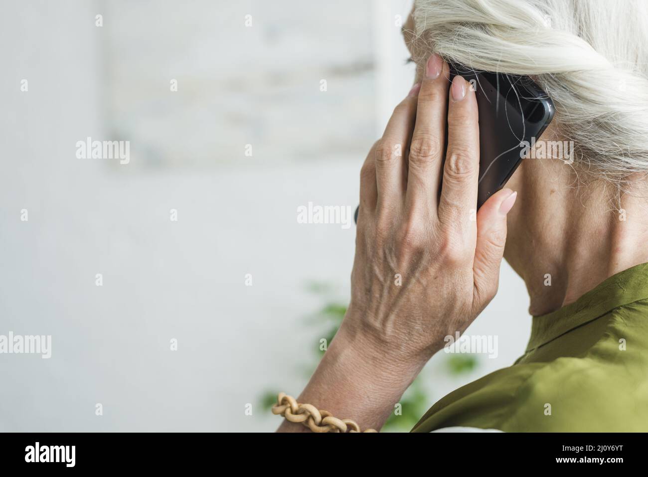 Die Hand einer älteren Frau mit dem Mobiltelefon. Hochwertige Fotos Stockfoto