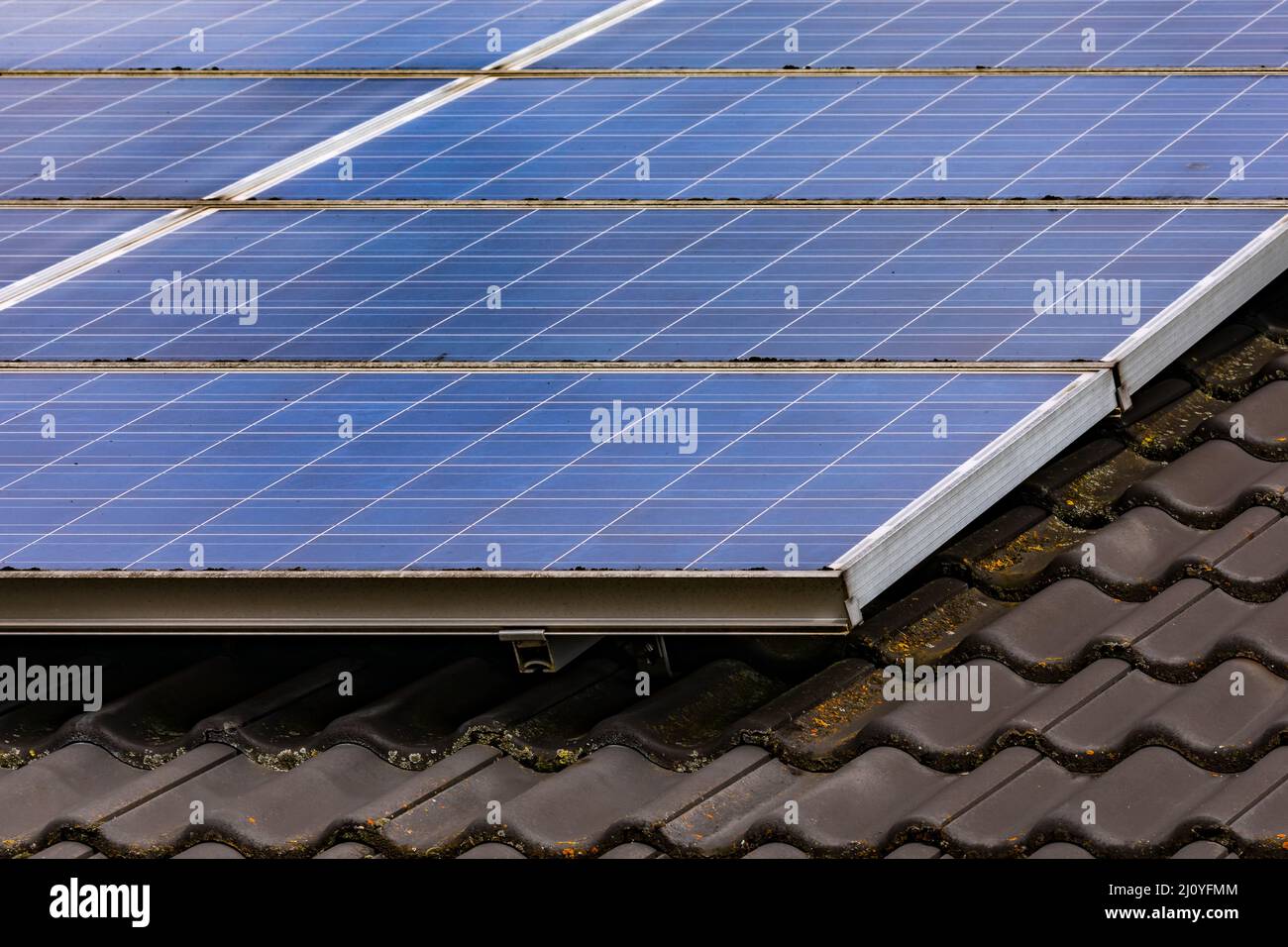 Solarzellen auf dem privaten Dach wandeln Sonnenlicht über Photovoltaikzellen direkt in elektrische Energie um Stockfoto