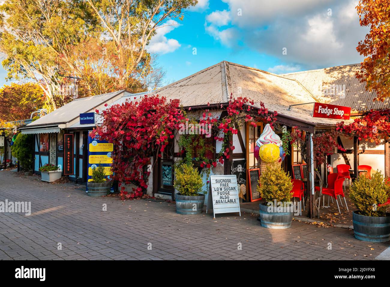 Adelaide Hills, South Australia - 24. April 2021: Kleine Geschäfte, die während der Herbstsaison bei Sonnenuntergang entlang der Straße in Hahndorf besichtigt werden können Stockfoto