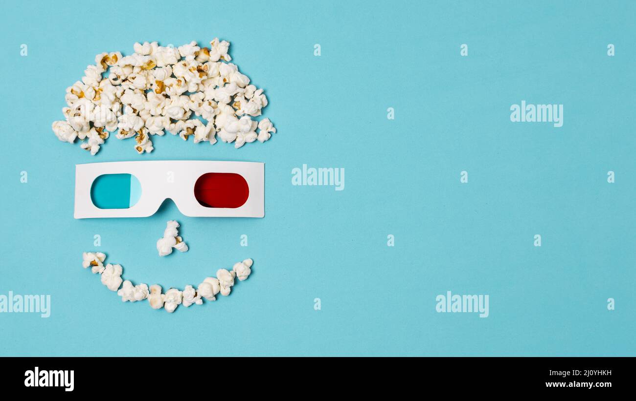 Smiley anthropomorphe Gesicht mit Popcorn gemacht 3D Gläser Kino Zeit Text. Hochwertige Fotos Stockfoto