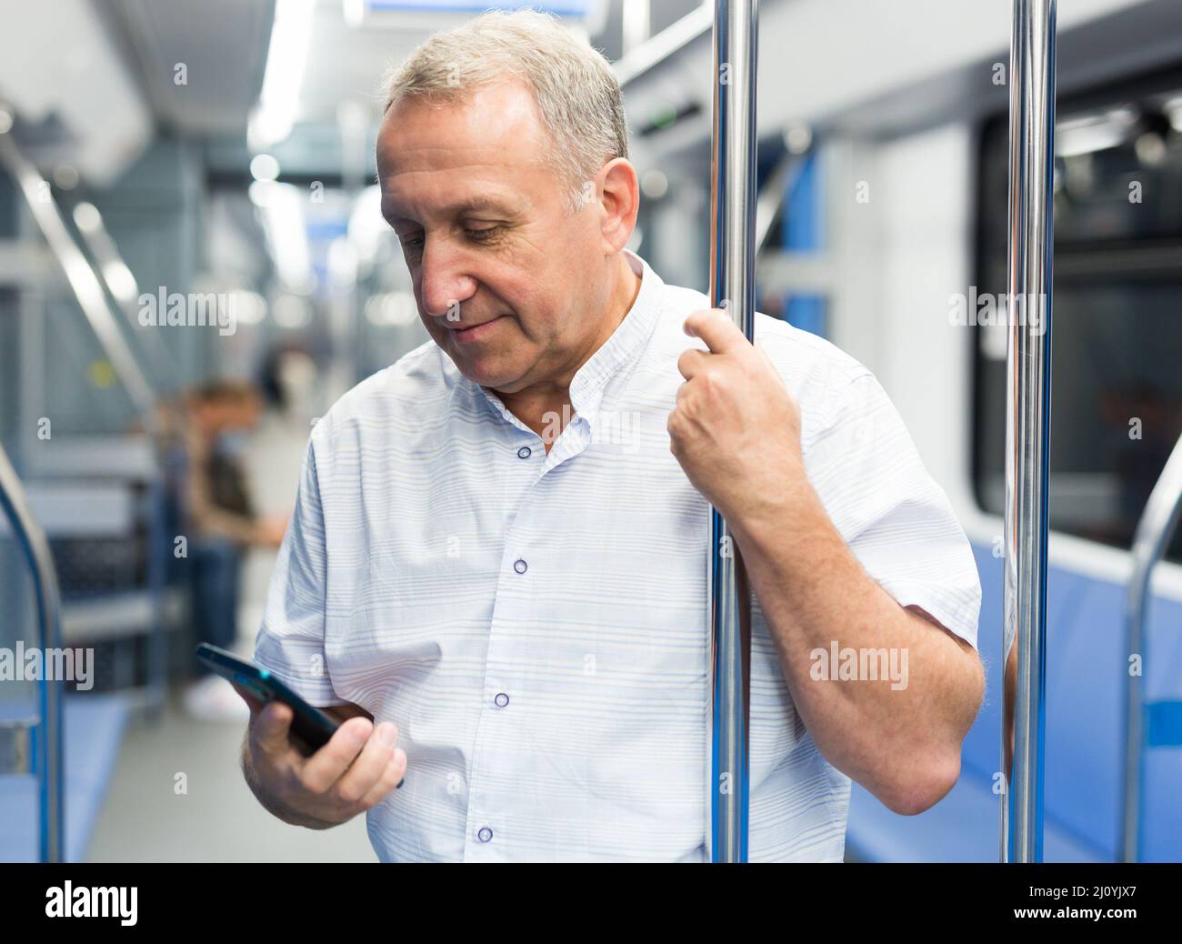 Reifer Mann, der im U-Bahn-Auto telefoniert Stockfoto