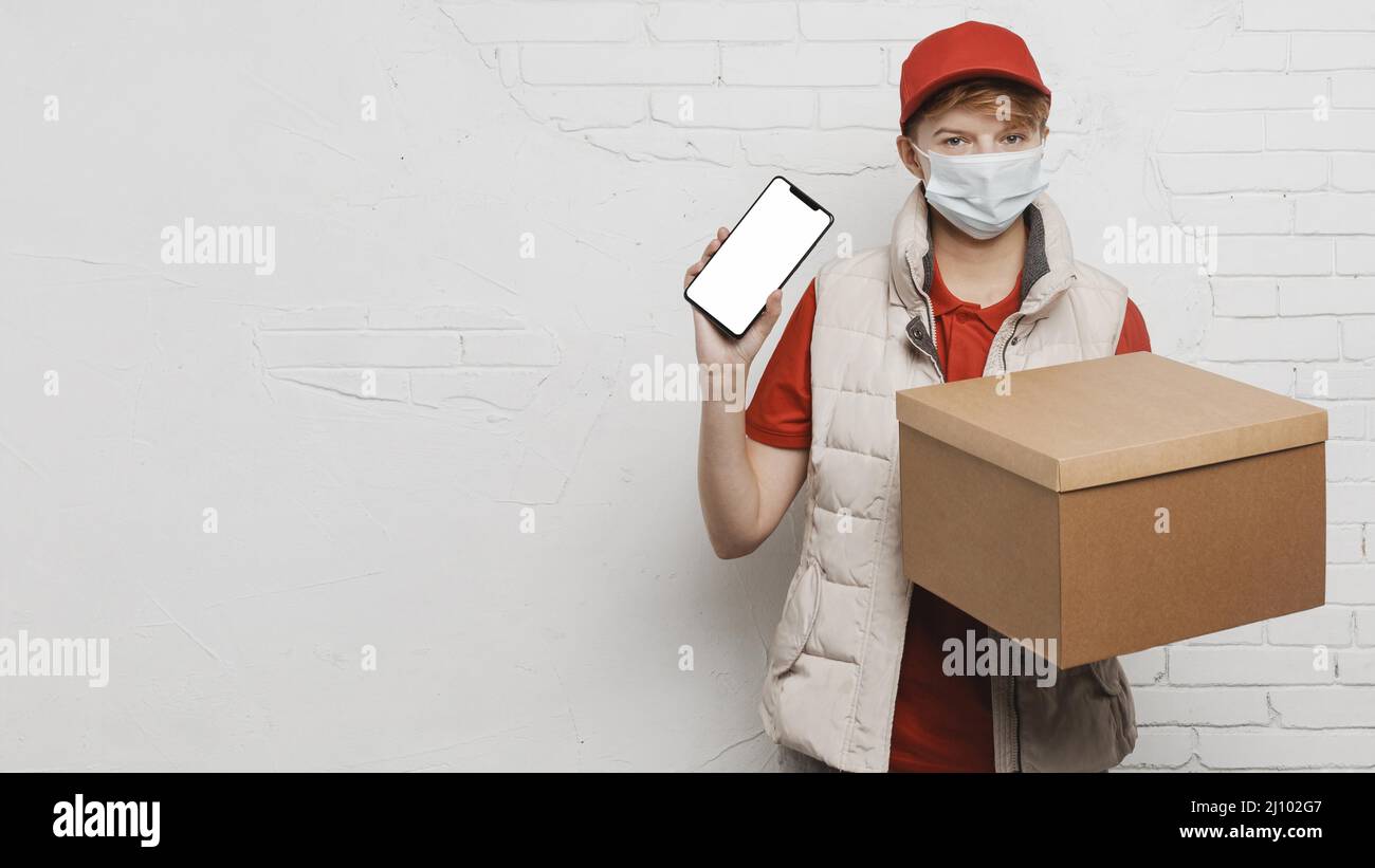 Mittelgroßer Typ, der das Telefon im Kasten hält Stockfoto