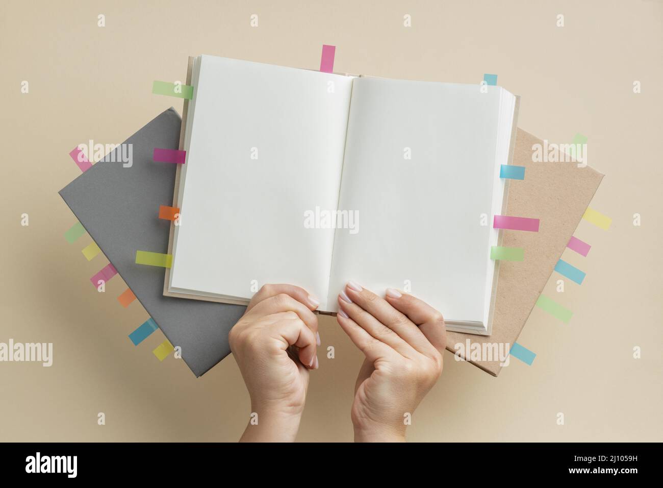 Person, die Bücher mit bunten Erinnerungsaufklebern hält Stockfoto