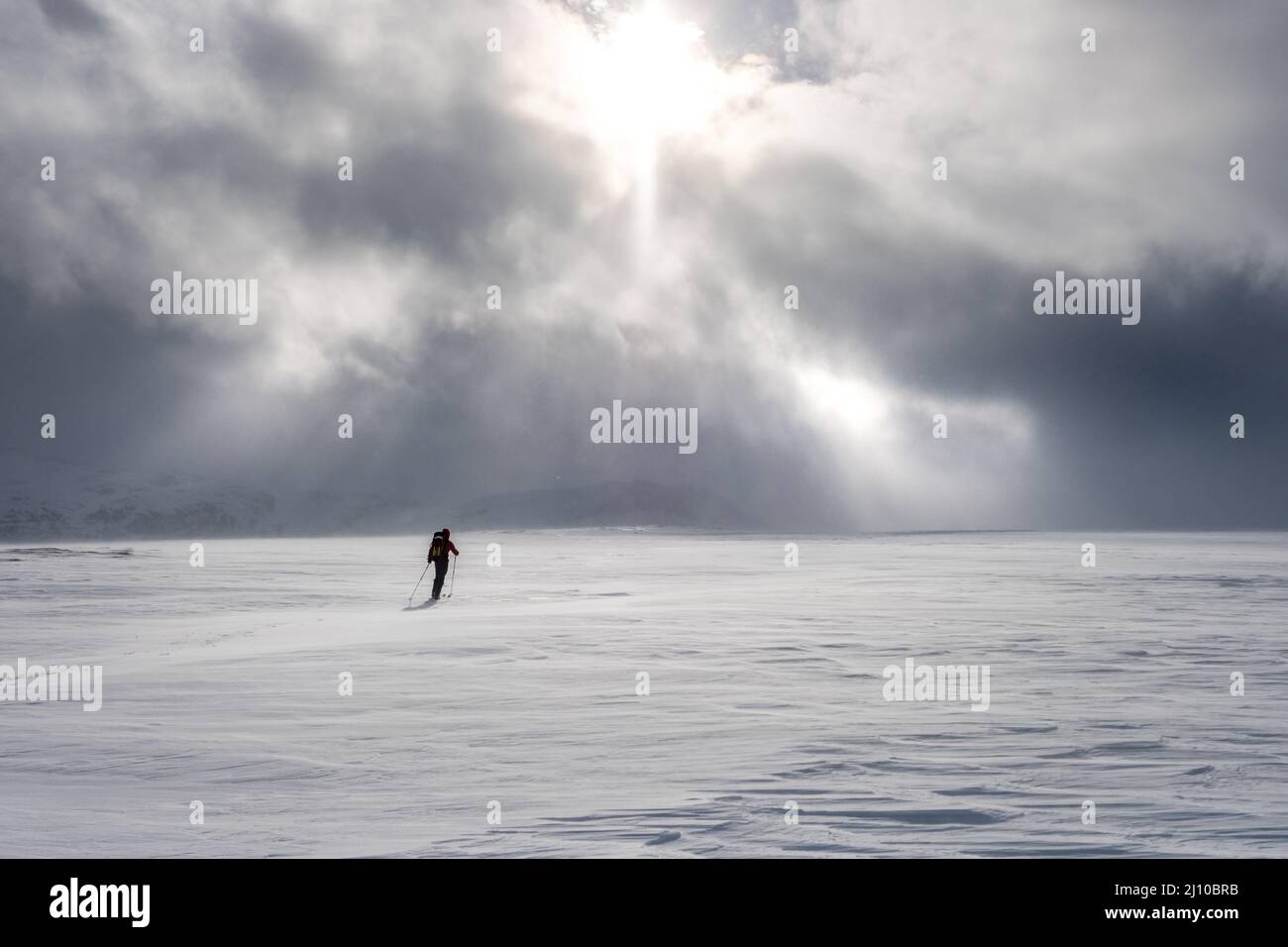 Ein einfacher Skifahrer Skitourengehen in den Bergen Norwegens mit einem drohenden Himmel vor uns Stockfoto
