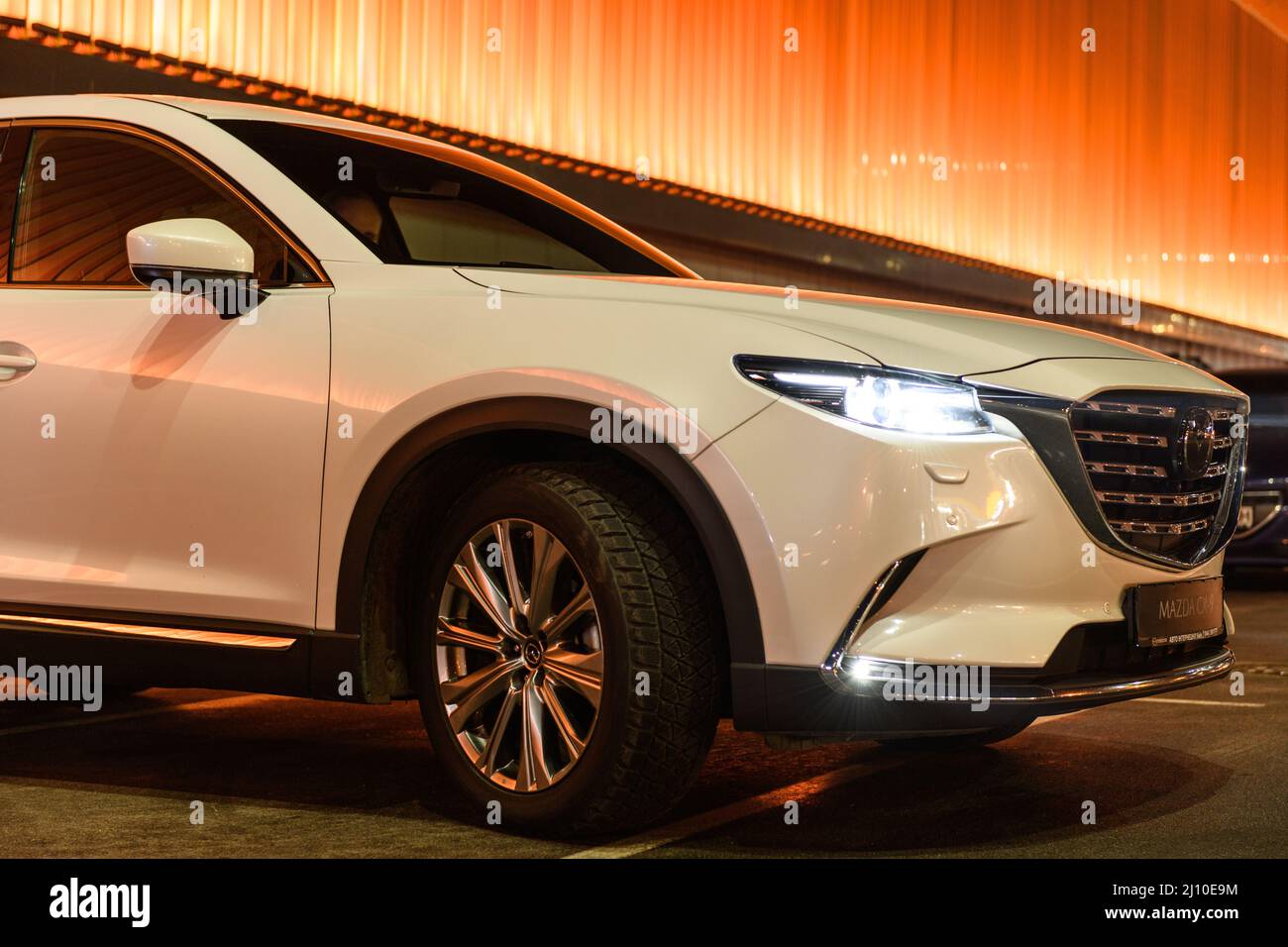 Kiew, Ukraine - 4. Dezember 2021: Der neue Mazda CX-9 in der Nähe der bunten beleuchteten Wand bei Nacht Stockfoto