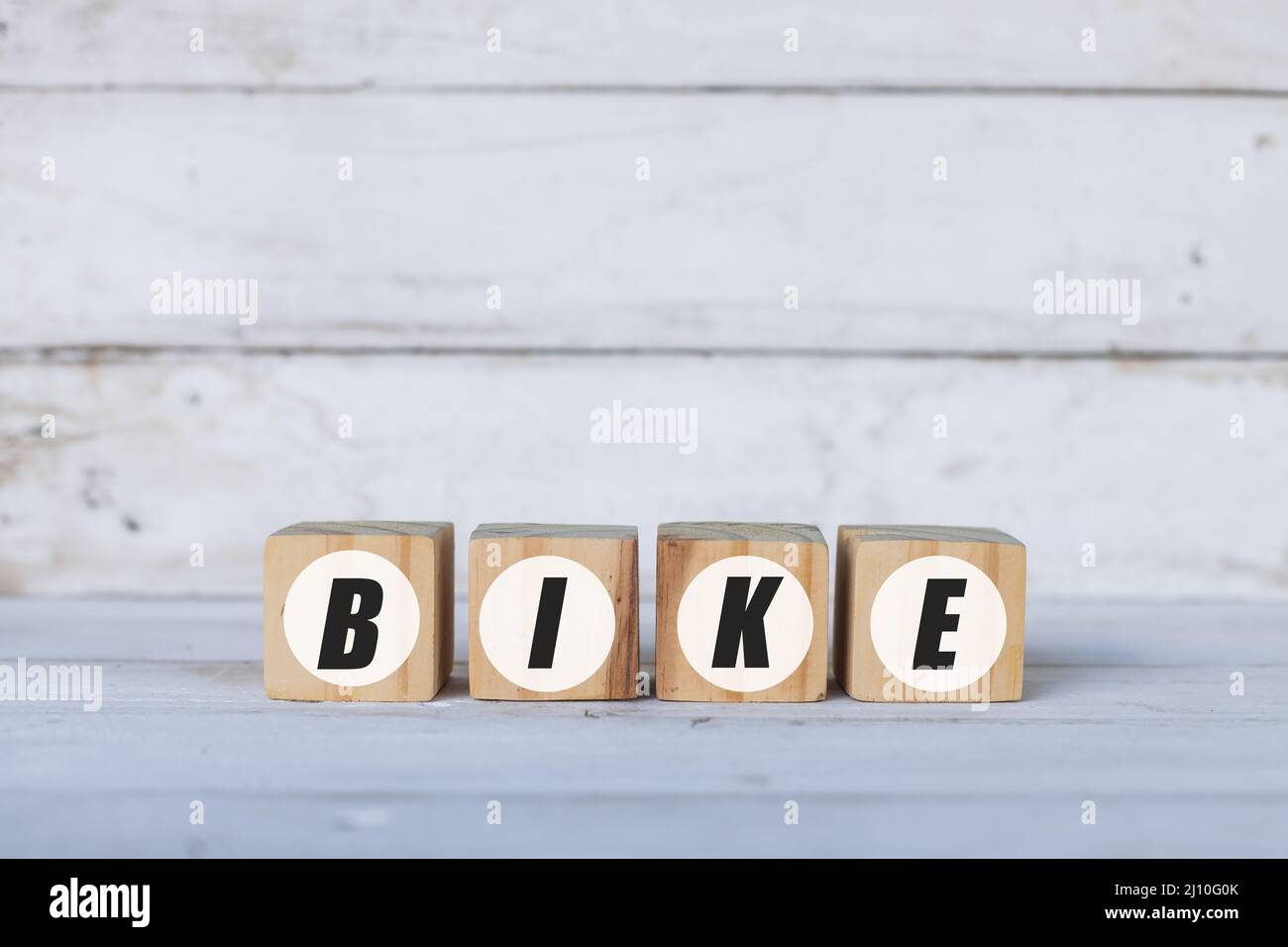 Fahrrad-Konzept auf Holzwürfeln oder Blöcken geschrieben, auf weißem Holzhintergrund. Stockfoto