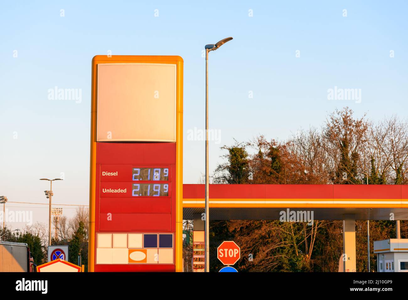 Tankstellenschild an einer Autobahn unter klarem Himmel bei Sonnenuntergang im Winter. Steigende Benzinpreise. Stockfoto