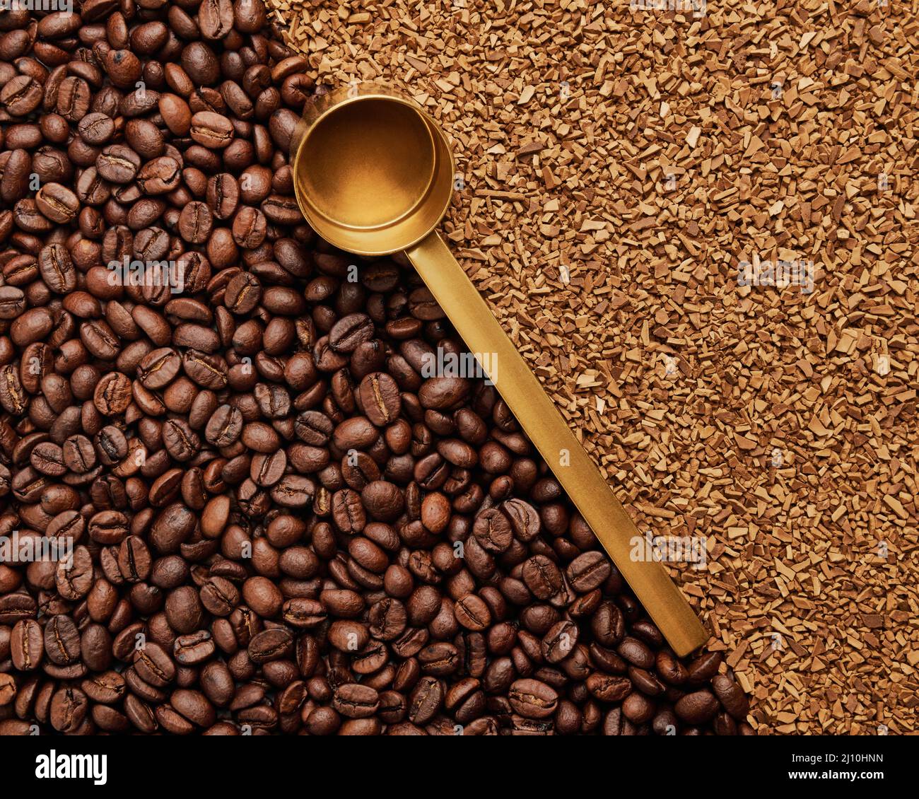 Hintergrund von frisch gerösteten Kaffeebohnen und Instant-Kaffee mit einem goldenen Messlöffel Stockfoto