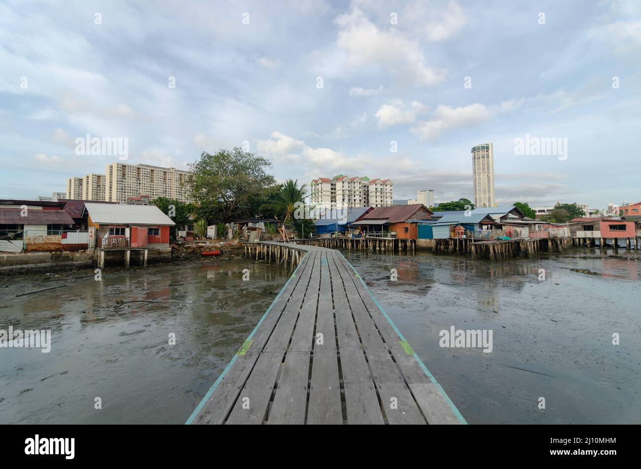 Holzbrücke des Clans Jetty, Penang. Hintergrund ist Stelzenhaus und KOMTAR-Gebäude Stockfoto