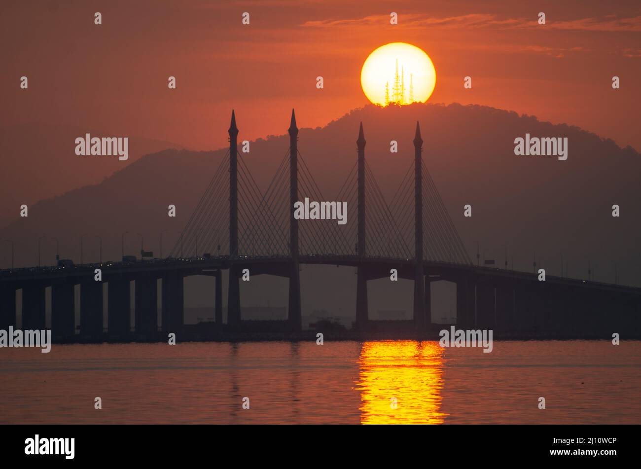 Morgendlicher Eigelb-Sonnenaufgang über der Penang Bridge und dem Tokkun Hill. Stockfoto