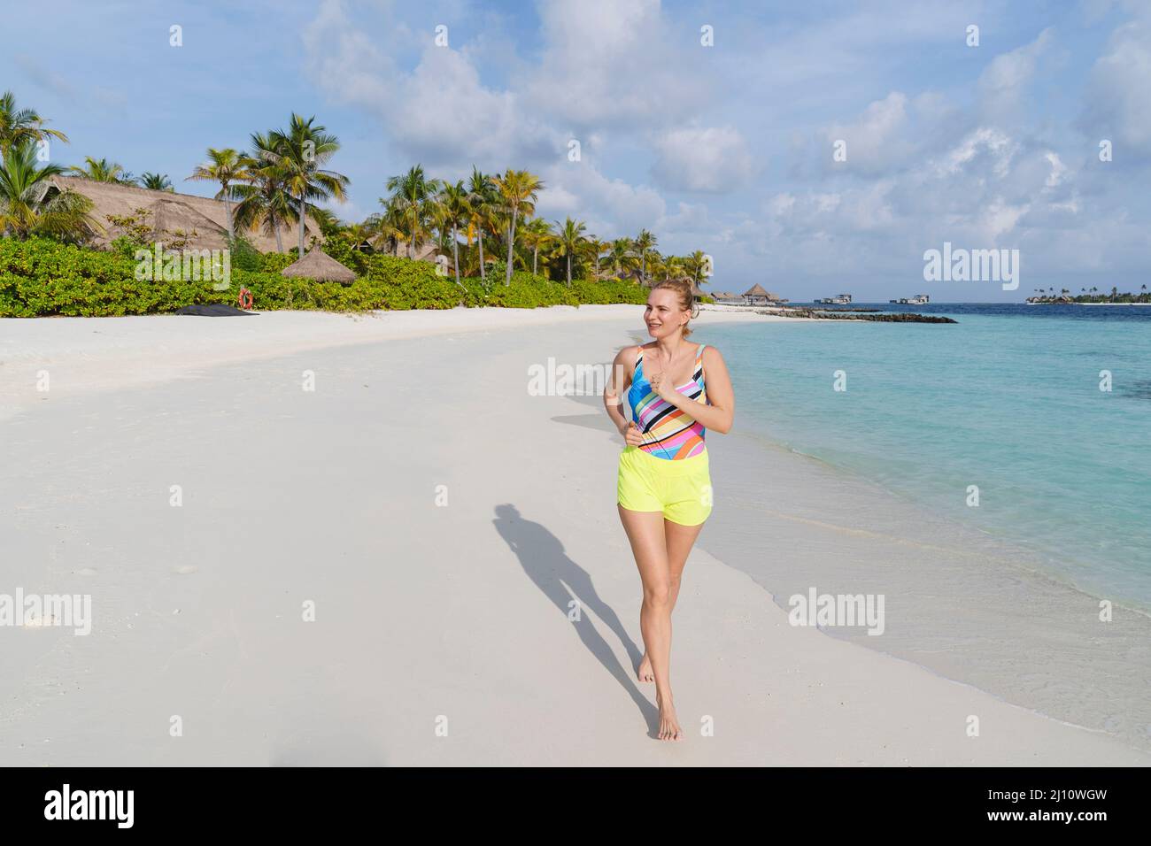 Eine sportliche Frau läuft am Meeresufer entlang. Stockfoto