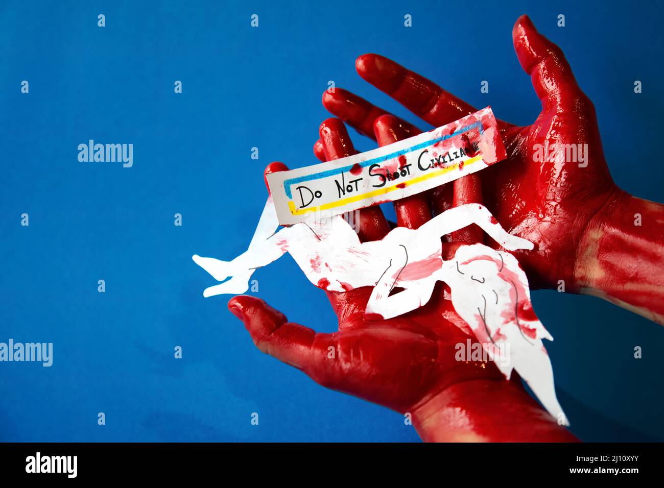 Blutige Hände halten einen Papierausschnitt des Körpers einer Frau und ein Schild mit der Bitte, nicht auf Zivilisten zu schießen, Farben der ukrainischen Flagge, mit Krieg gegen Ru Stockfoto