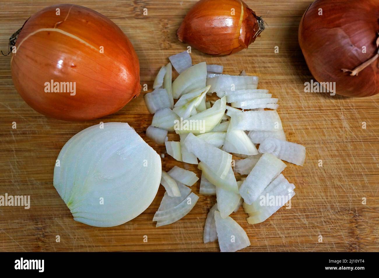 Gehackte Zwiebel auf rustikalem Holztisch Stockfoto