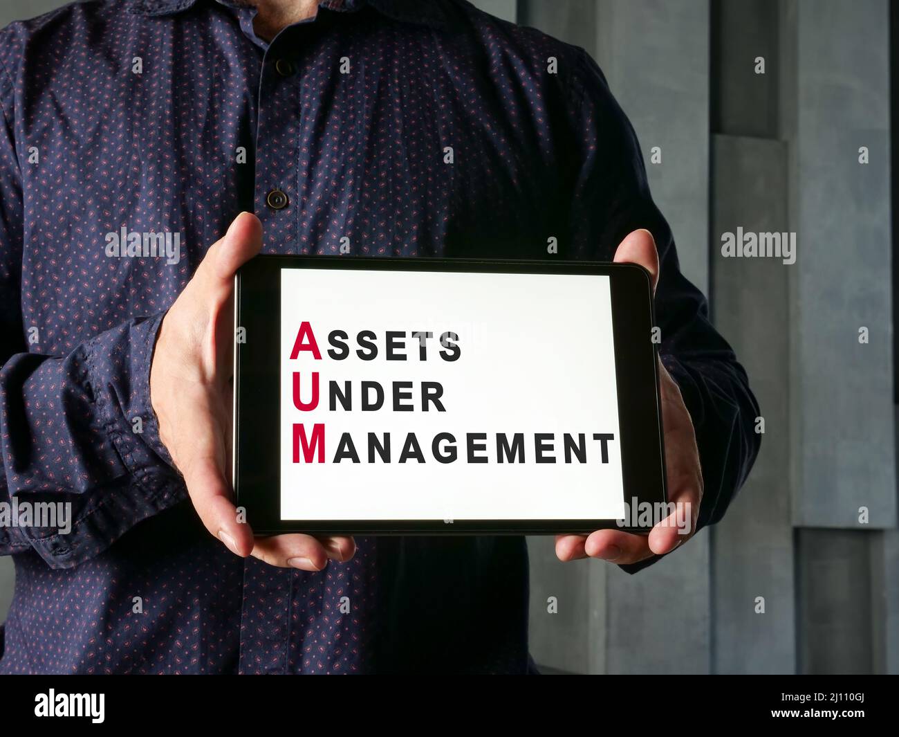 Assets under Management – AUM-Konzept. Mann zeigt Tablet. Stockfoto