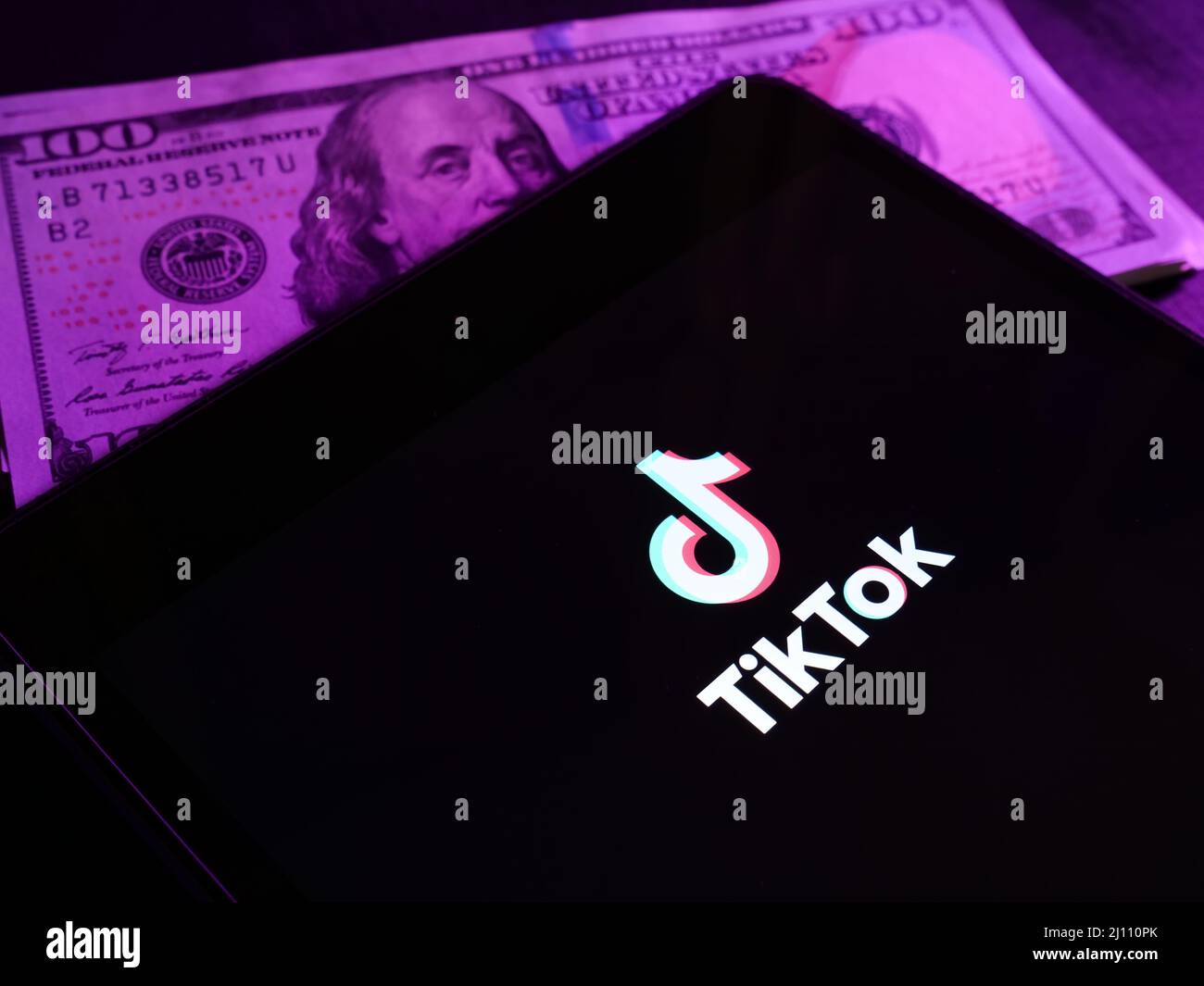 KIEW, UKRAINE - 20. März 2022. Monetarisierung von TikTok. Bildschirm mit Logo und Geld. Stockfoto