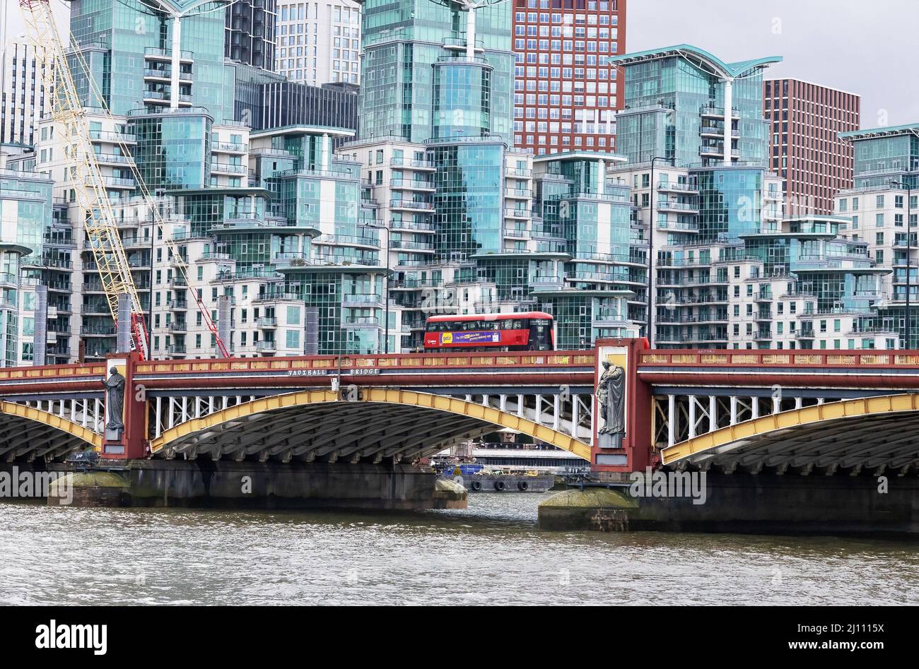 Blick auf London; Ein London Bus überquert die Themse über die Vauxhall Bridge vor moderner britischer Architektur, Vauxhall, London UK Stockfoto