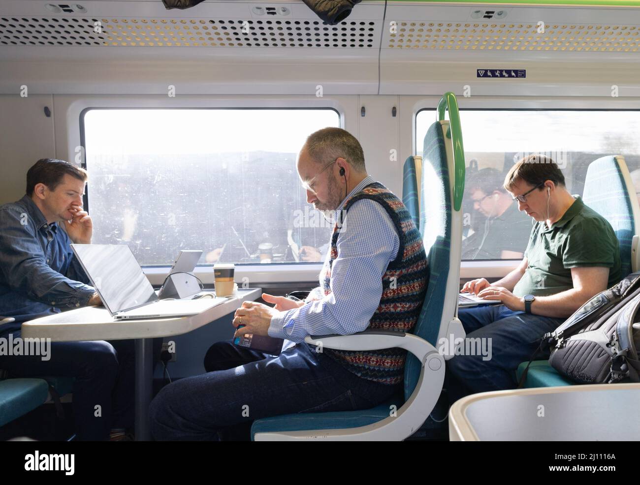 Bahnreisende Großbritannien; Bahnpendler, die mit Computern im Zug arbeiten, Großbritannien Stockfoto
