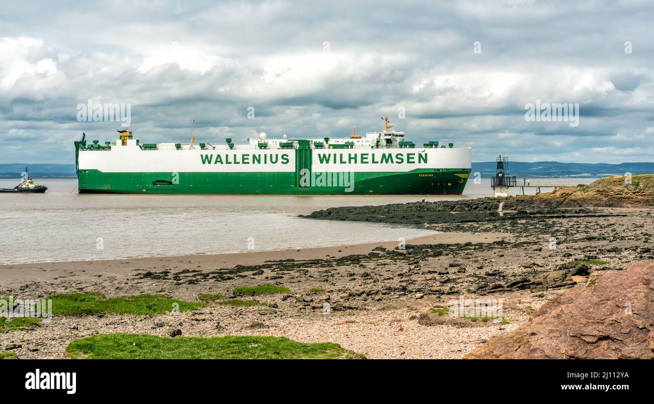 Portishead Strand von der Esplanade Road mit vorbeifahrendem großen Fahrzeugträger im Hintergrund. Auch ein Blick auf den Battery Point Lighthouse, Somerset, England Stockfoto