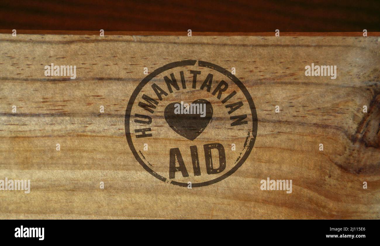 Stempel für humanitäre Hilfe auf Holzkiste gedruckt. Hilfe für Flüchtlinge, Freiwilligenarbeit und Rettung während des Krisenkonzepts. Stockfoto