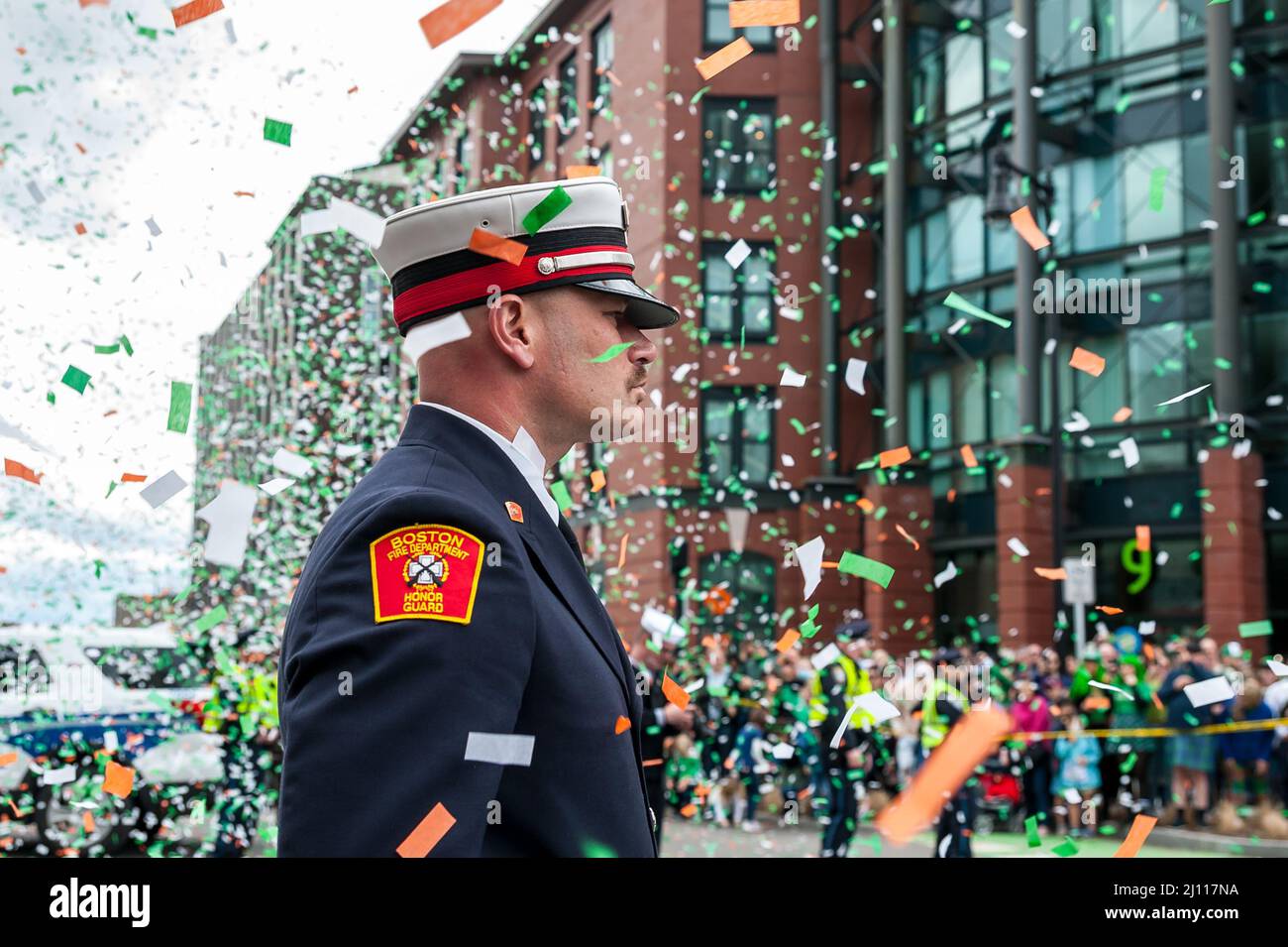 Ein Mitglied der Boston Fire Honor Guard steht stolz auf das fallende Konfetti während der South Boston St. Patrick's Day Parade. Stockfoto