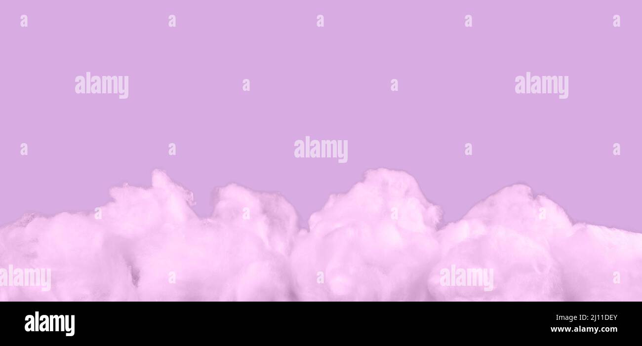 Rosa Baumwollwolken auf violettem Hintergrund. Monochromes surreales Banner mit Kopierraum. Hochwertige Fotos Stockfoto