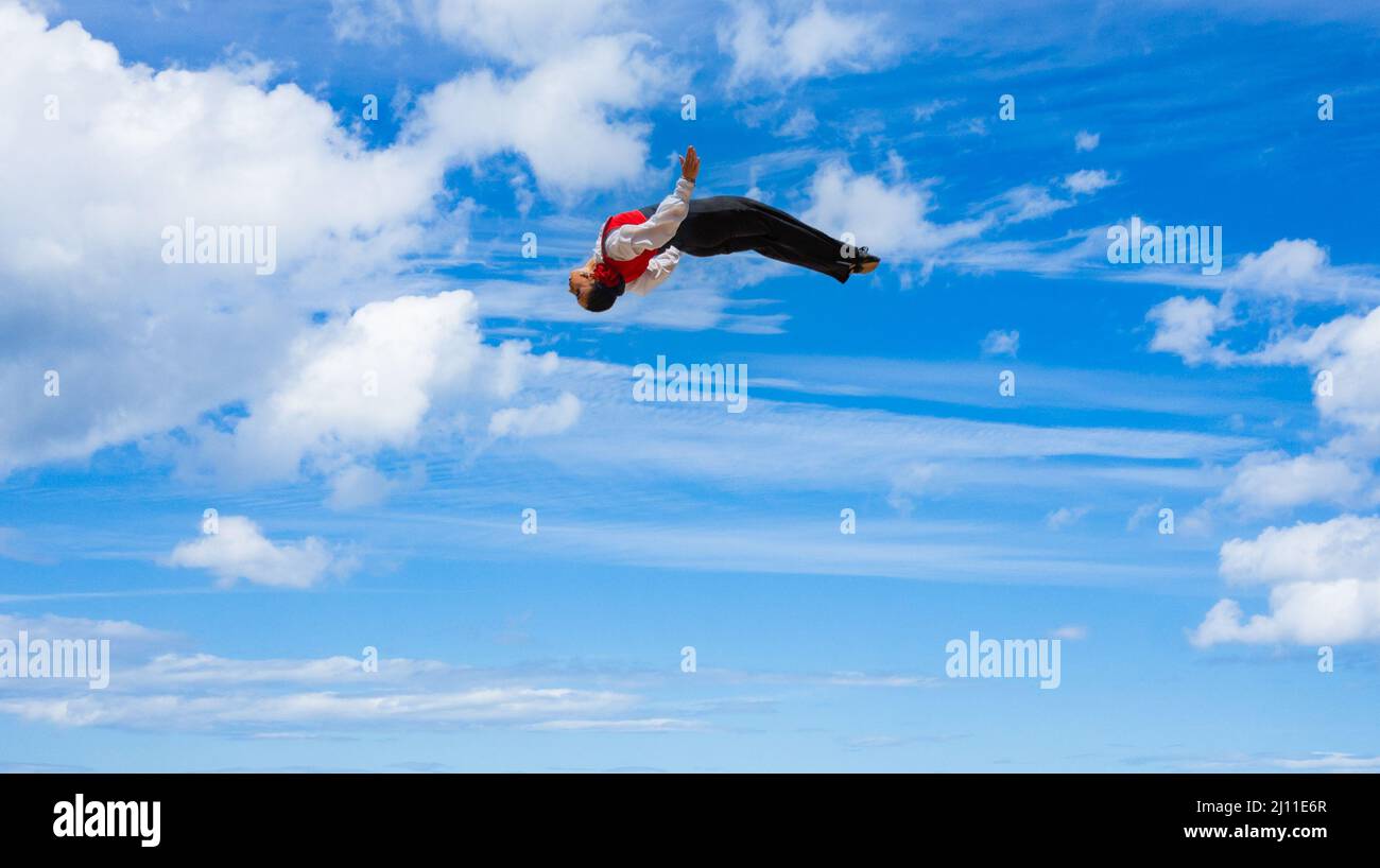 Weibliche Zirkusdarstellerin hoch über einem Trampolin. Stockfoto