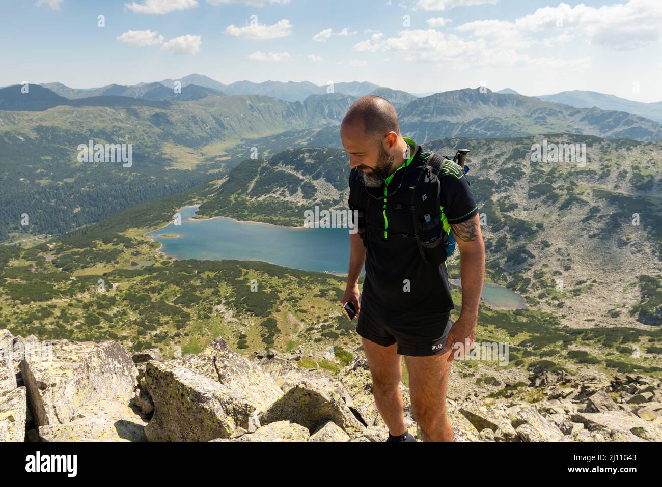 Männlicher Wanderer auf dem Rilets Summit um 2713m Uhr mit Blick auf den Stinky- oder Smradlivoto-See im Rila-Nationalpark und Naturschutzgebiet, Bulgarien, Balkan Stockfoto
