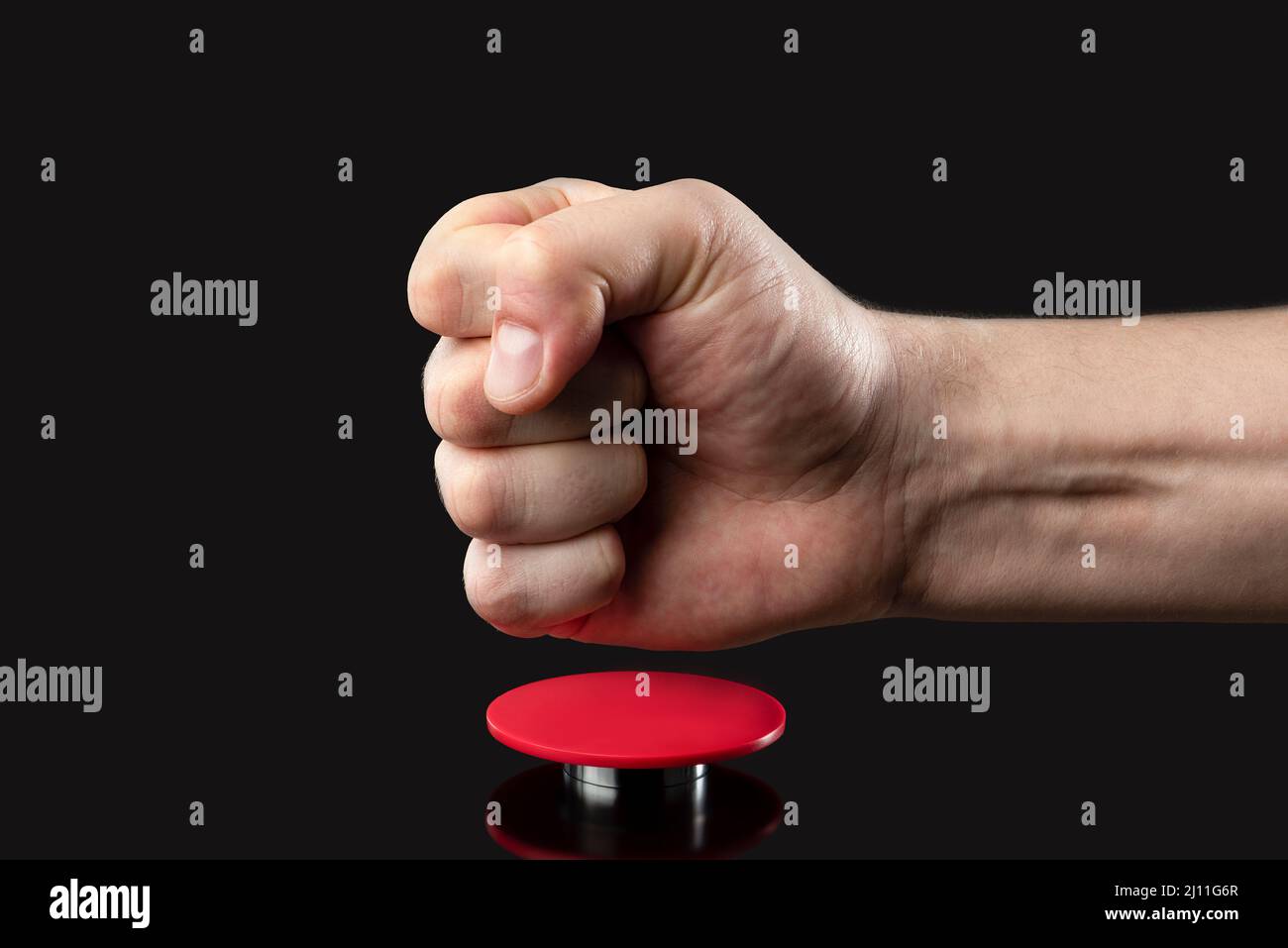 Die Hand eines Mannes drückt einen großen roten Knopf. Rote Taste auf dunklem Hintergrund. Die Drohung mit nuklearen oder chemischen Massenvernichtungswaffen. Rakete Stockfoto