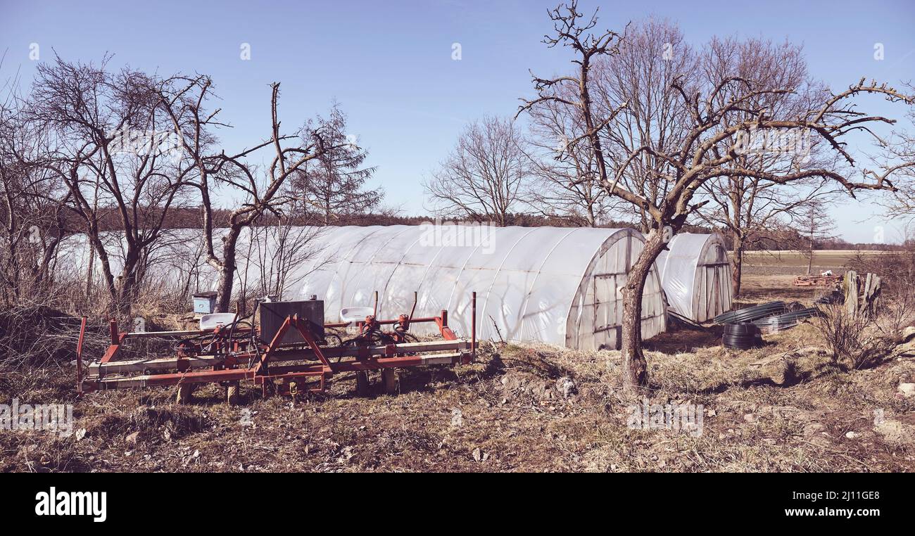 Farmszene mit Kunststoff überzogenen Gewächshaus, Farbtonung aufgetragen. Stockfoto