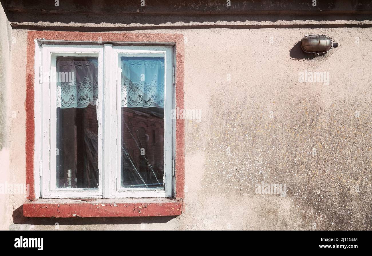 Altes Holzfenster in einem verwitterten Gebäude, Farbtonung angewendet. Stockfoto