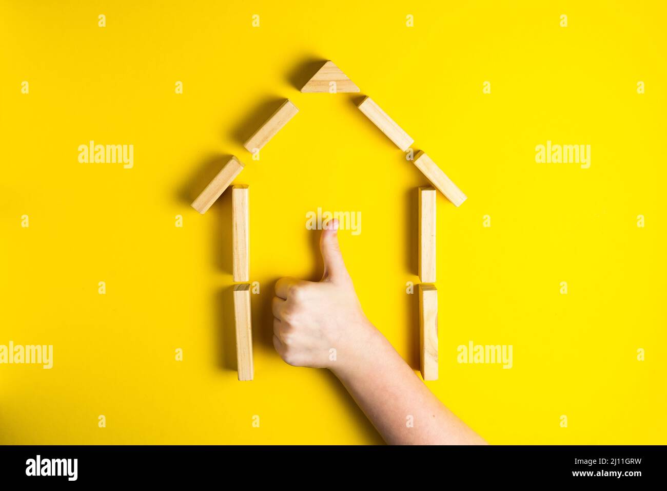 Draufsicht auf Kinderhand, Nahaufnahme der Bauklötze, die ok, Haus, Holzhütte zeigen Stockfoto