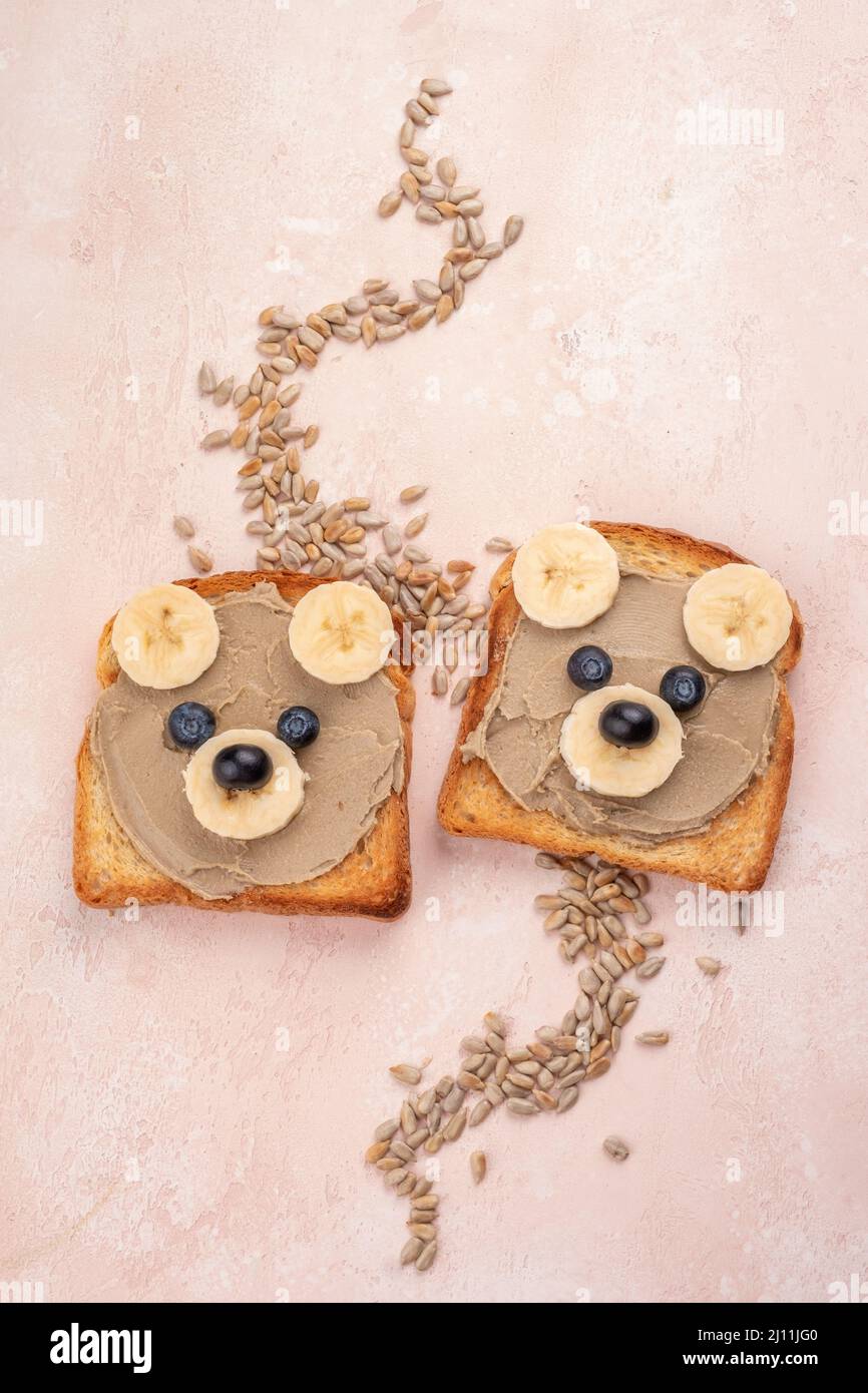 Lustige Kinder tragen zum Frühstück Toast mit Nussbutter Stockfoto