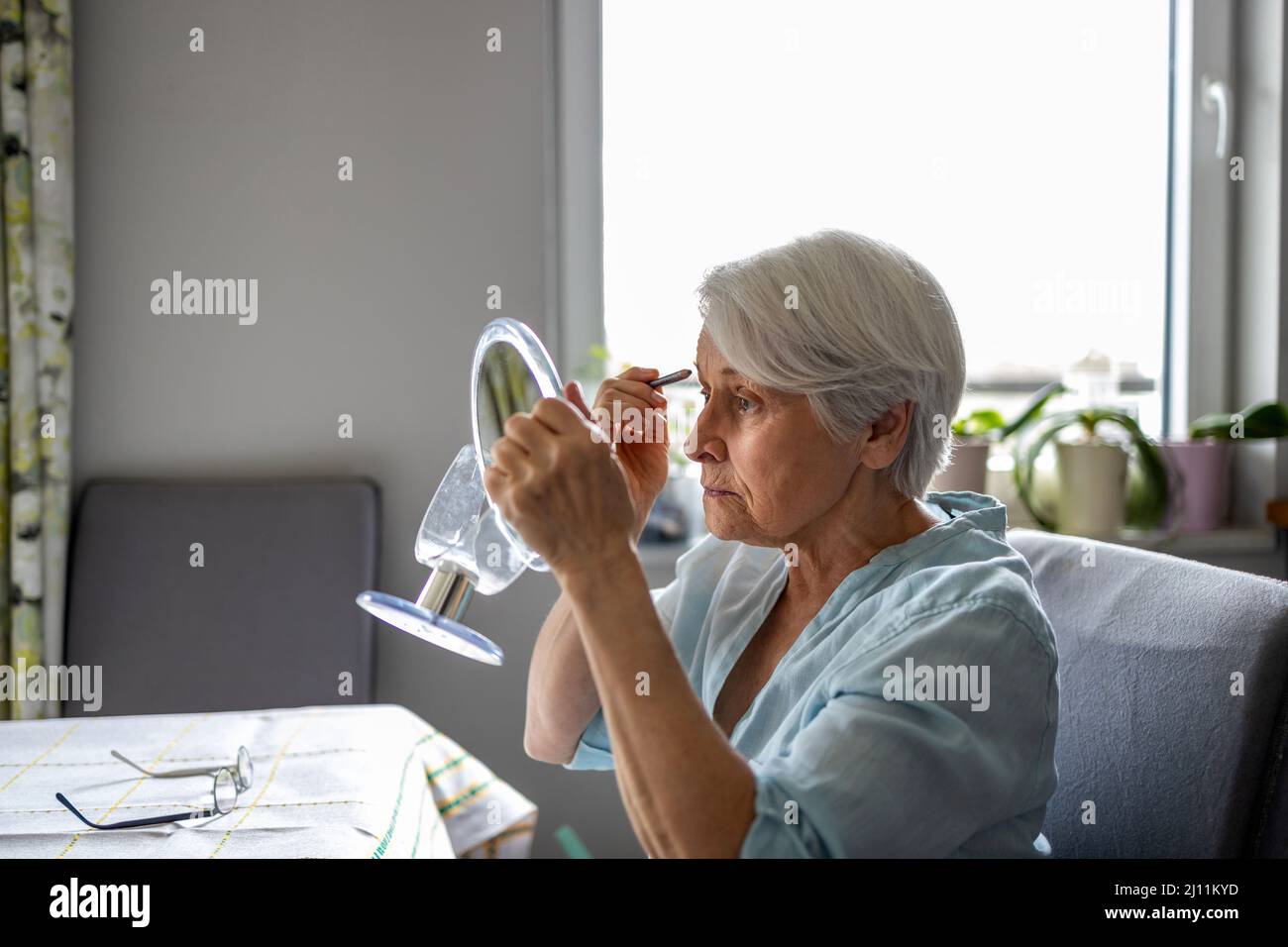 Ältere Frau, Die Vor Dem Spiegel Make-Up Macht Stockfoto