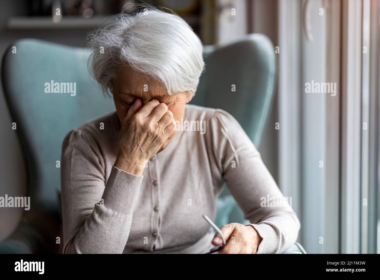 Ältere Frau, die an Kopfschmerzen leidet Stockfoto