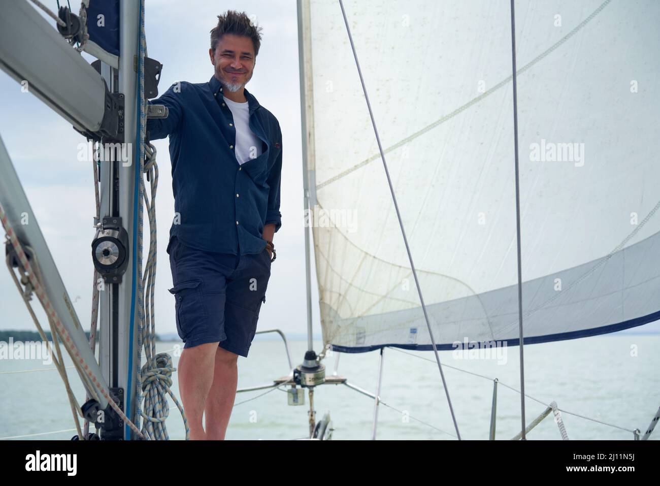 Porträt eines selbstbewussten, reifen Alters, mittleren Alters, eines Mannes mit mittlerem Erwachsenenalter im Jahr 50s, glückliches Lächeln. Im Freien, Seemann an Bord des Segelbootes, Stockfoto