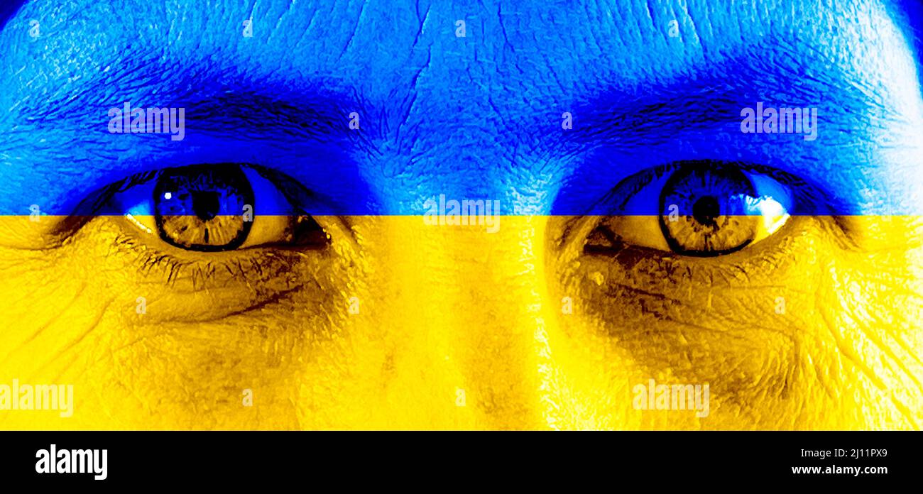 Ukrainische Frau blickt mit der Flagge der Ukraine im Gesicht Stockfoto