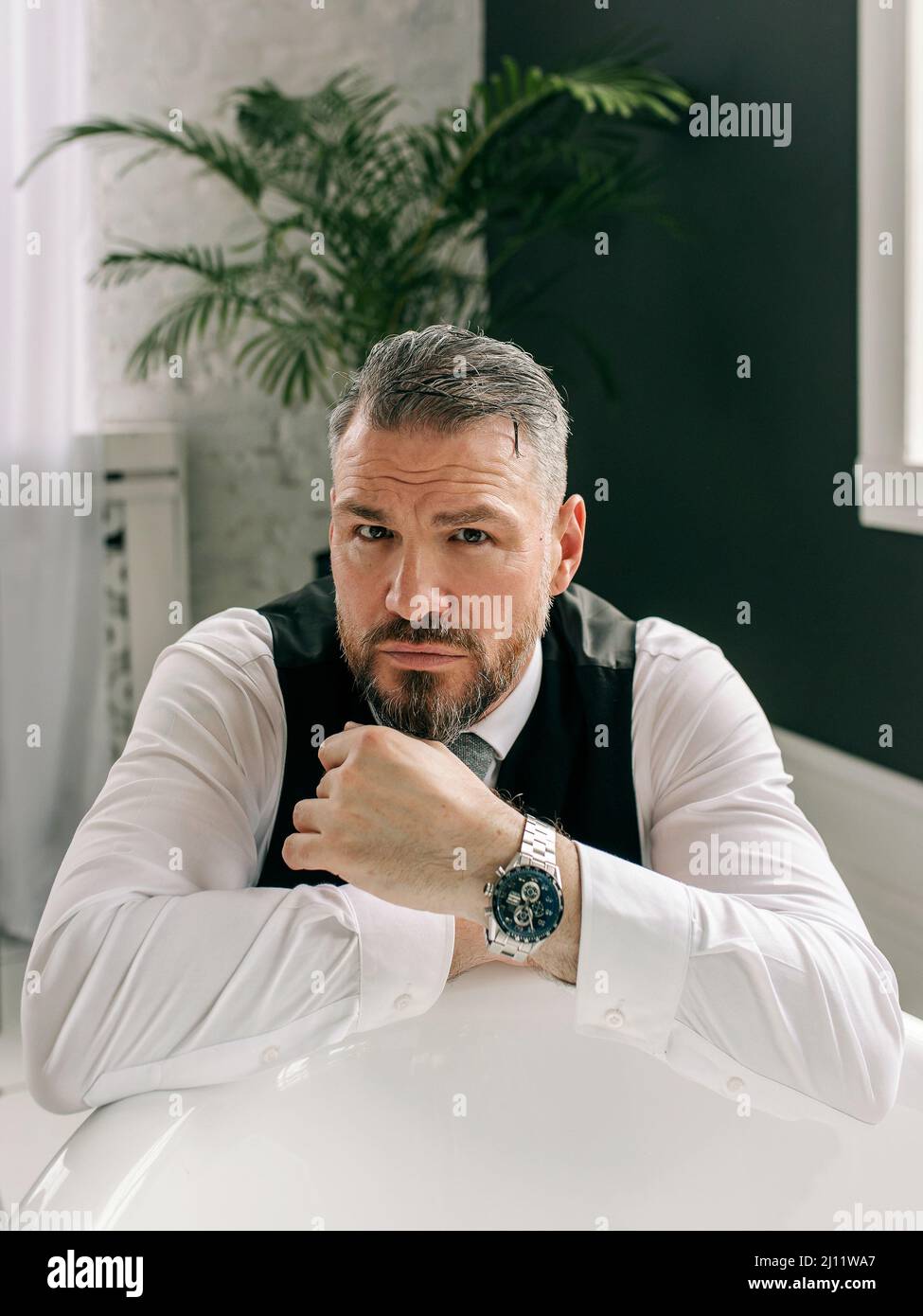 Schöner reifer mutiger, stilvoller schottischer Geschäftsmann im Kilt und Anzug im Badezimmer. Stil, Heimarbeit, Mode, Lifestyle, Kultur, Ethnische Zugehörigkeit Stockfoto