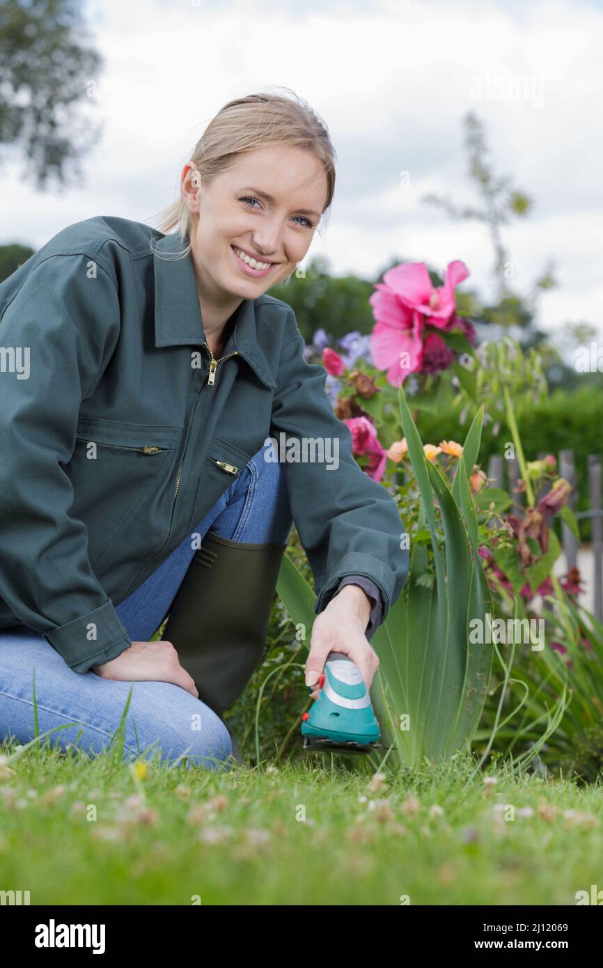 Gärtnerin mit Handstrimmer im Garten Stockfoto
