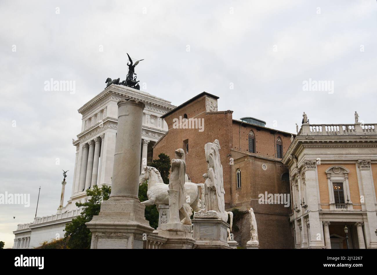 Statuen auf der Piazza del Campidoglio (Kapitolinische Hügel) mit Blick auf die Basilika der Heiligen Maria vom Altar des Himmels und die Viktor Emmanuel II. Nationa Stockfoto